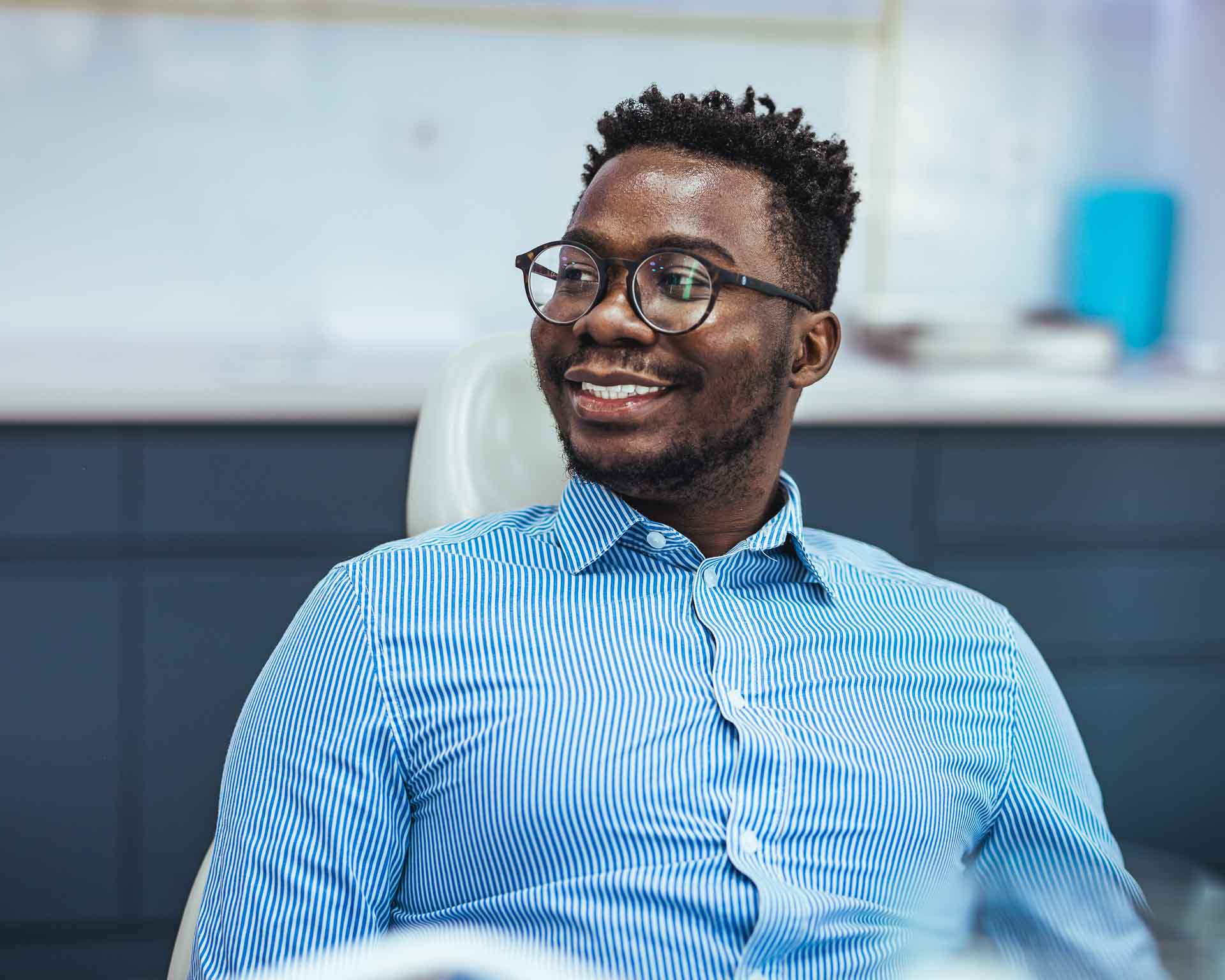 Young Man Relaxing in Dental Chair Smiling After Routine Checkup with Milan Sata DDS at Grand Blanc Dental Center in Grand Blanc, Michigan
