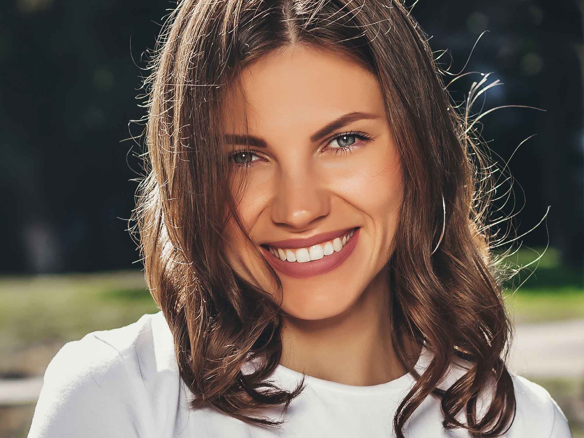 Confident woman smiling naturally representing the benefits of cosmetic dentistry in Grand Blanc, Michigan